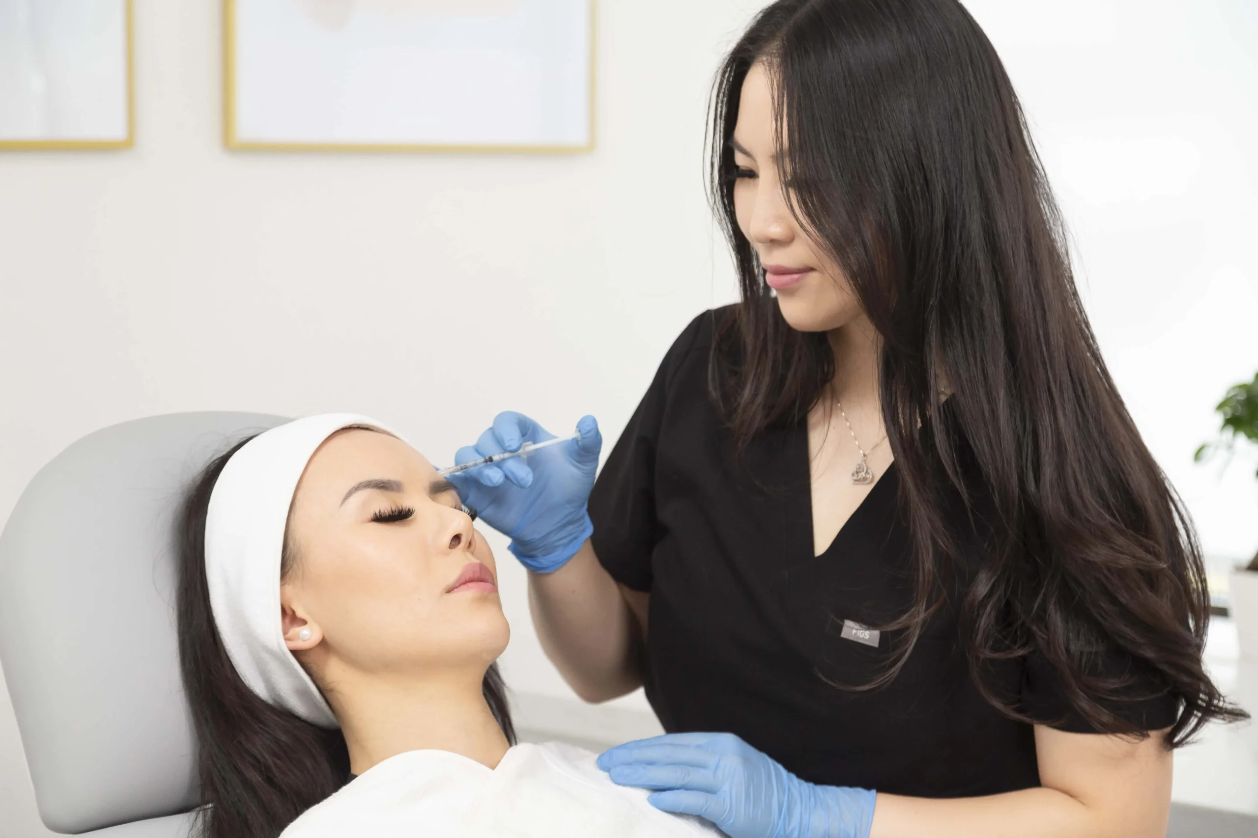 Aesthetic provider treating patient’s jawline with cosmetic injection