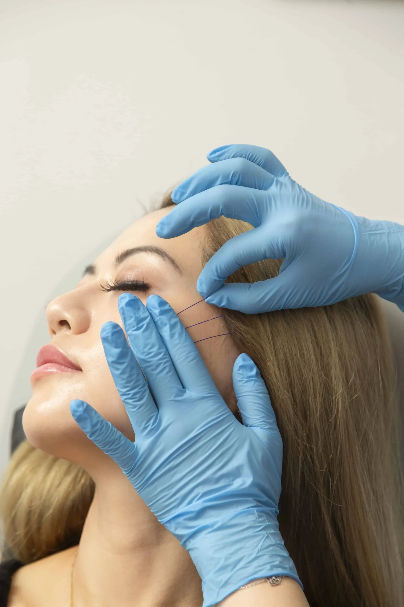 Skincare professional examining woman’s face before treatment